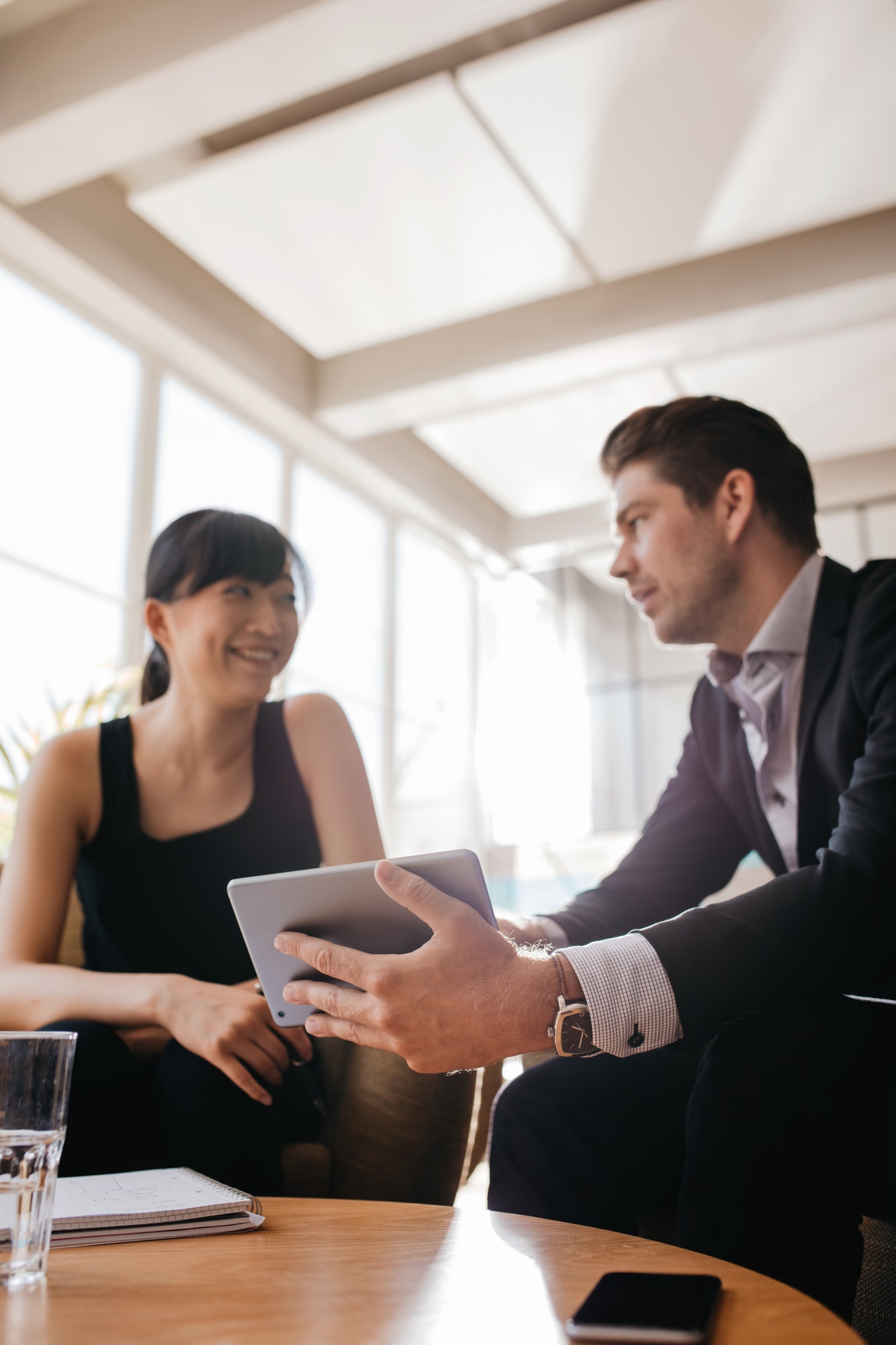 Businessman showing presentation to female colleague on tablet